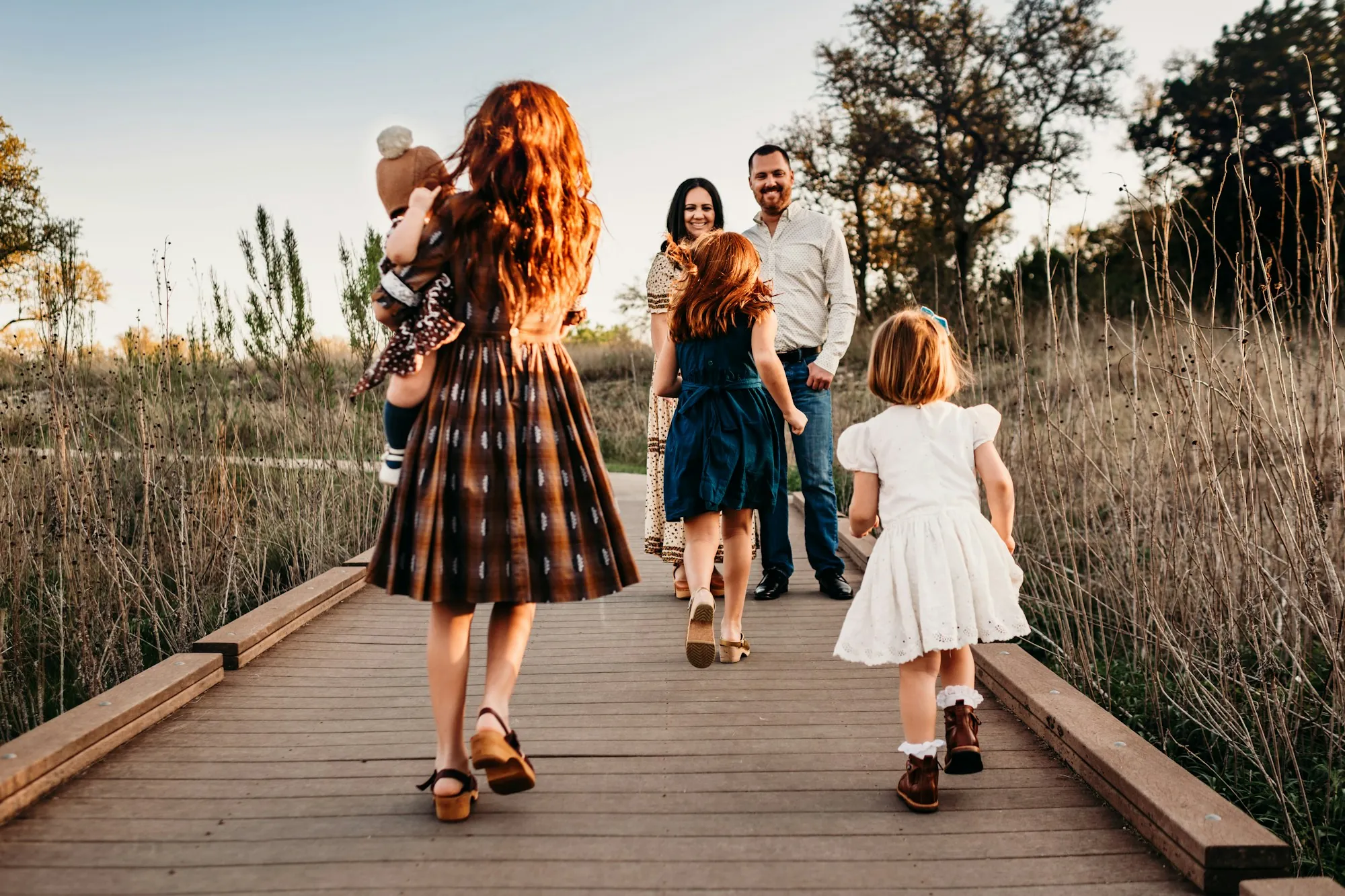 Mother and children walking down a boardwalk path