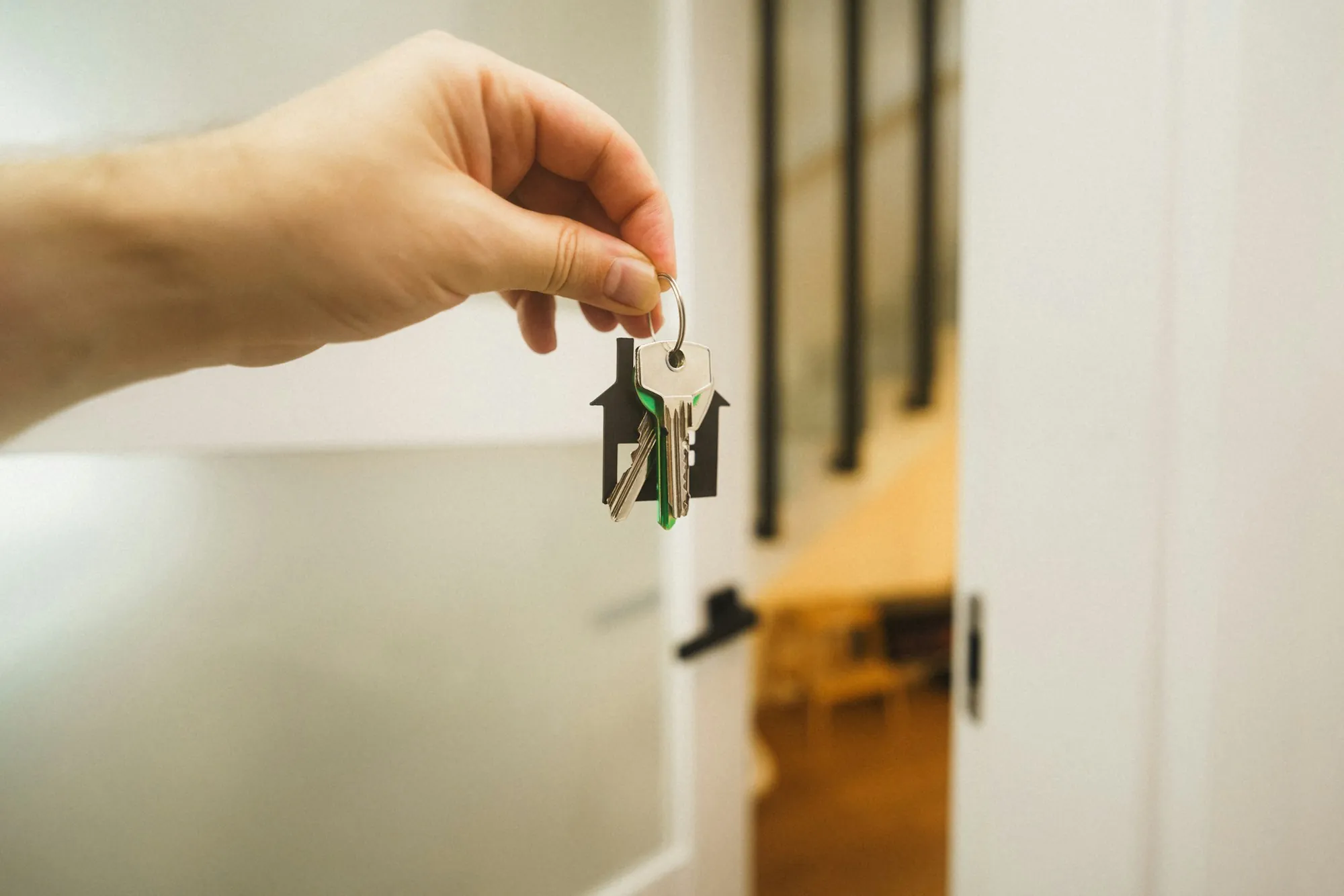 Hand holding house keys inside a new home, a fresh start that calls for updating a life insurance beneficiary after divorce in Wilmette