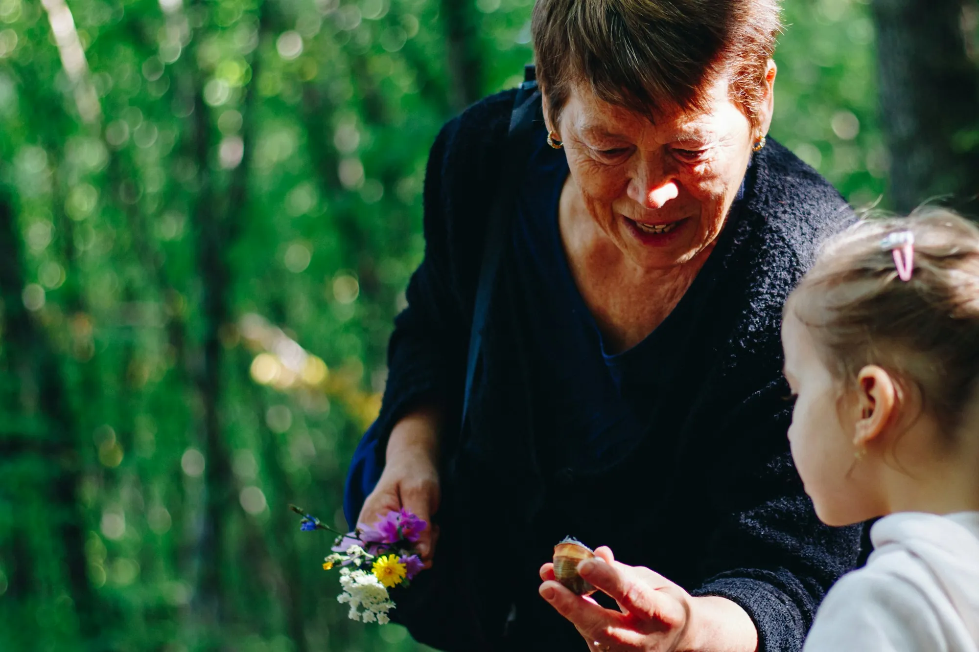Grandmother showing her granddaughter a flower